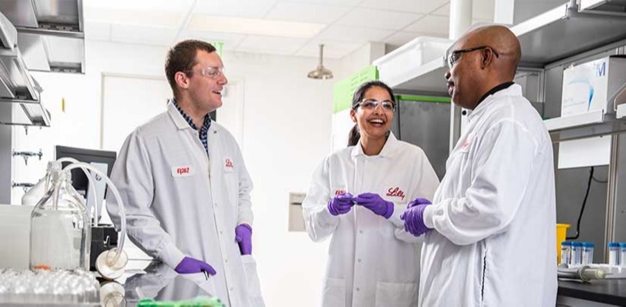 three lilly scientists talking in lab