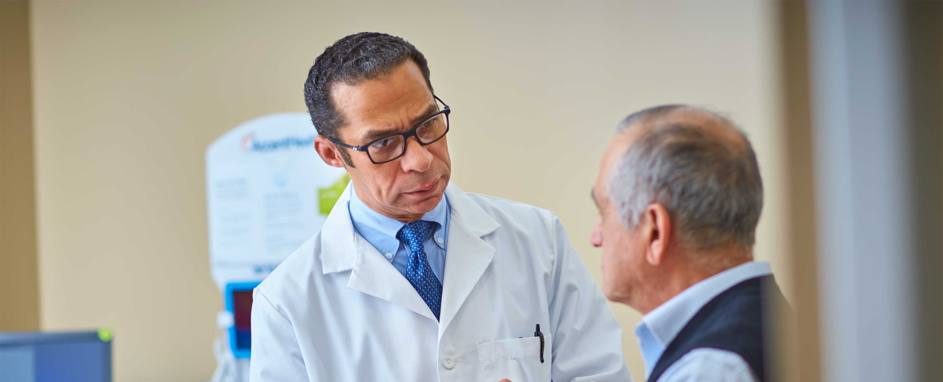 doctor talking to elderly male patient in exam room