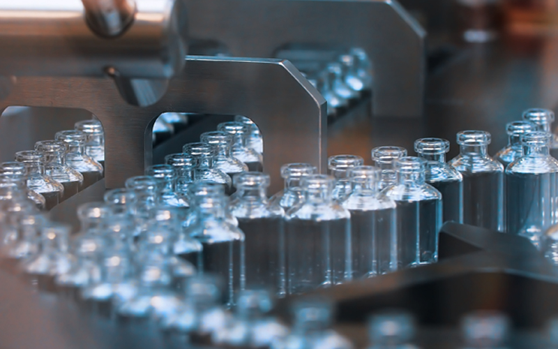 Empty glass vials in an assembly line. 