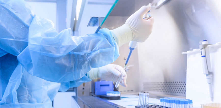 scientist in PPE with pipette in lab setting