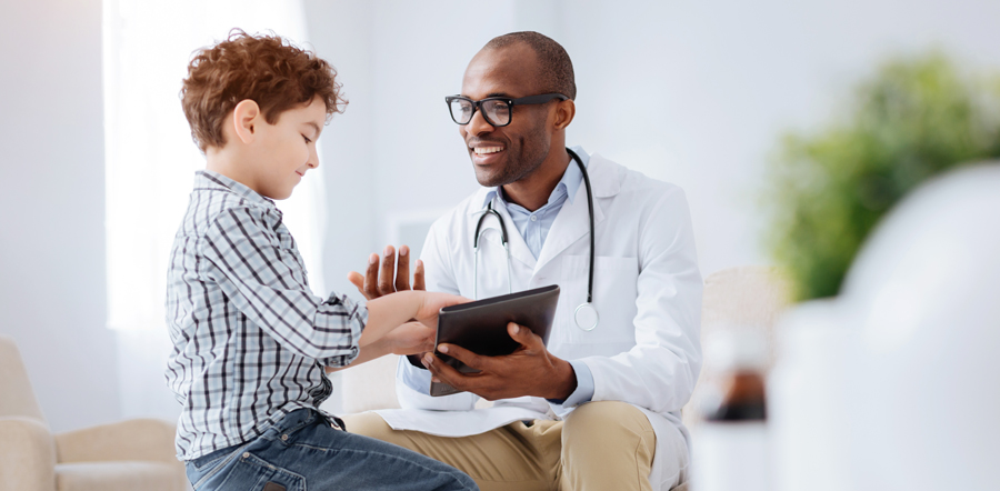 Black-male-physician-with-glasses-and-boy-touching-notebook