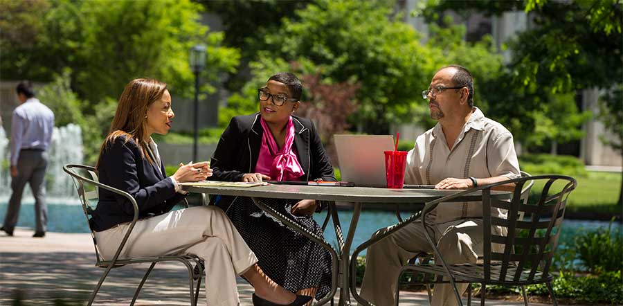 three people sitting outside in lilly courtyard