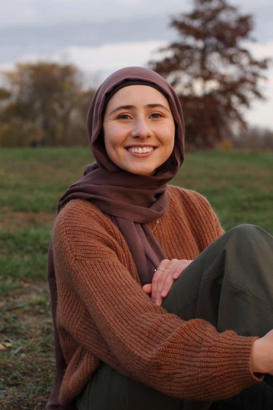 Sidra sitting on the grass posing for photo