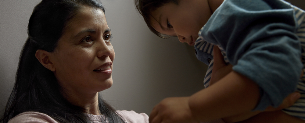 A woman holding and looking at a child. 