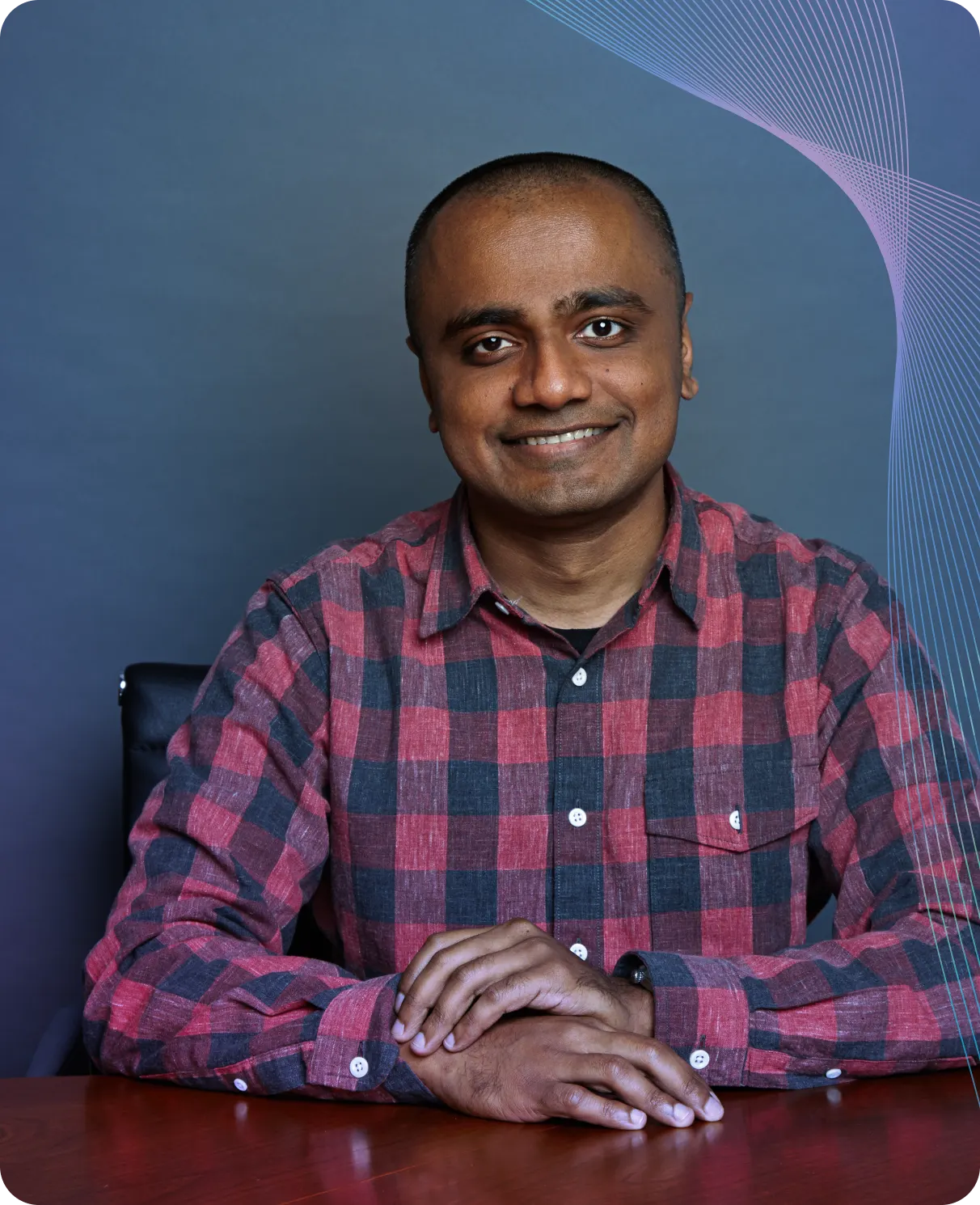 Shano from Plaid seated and smiling in a plaid shirt — sharing insights on the future of financial services and innovation