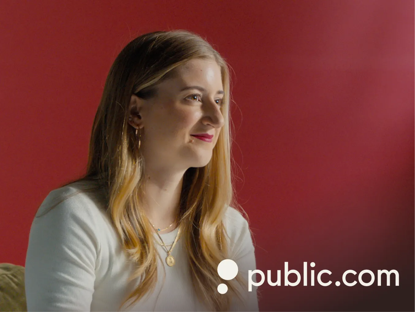 Public.com advertisement featuring MaryAlexa Divver, Head of Product, Infrastructure & Assets. She has long blonde hair, wearing a white top and gold jewelry, sitting against a red background. The Public.com logo is visible at the bottom right of the image.