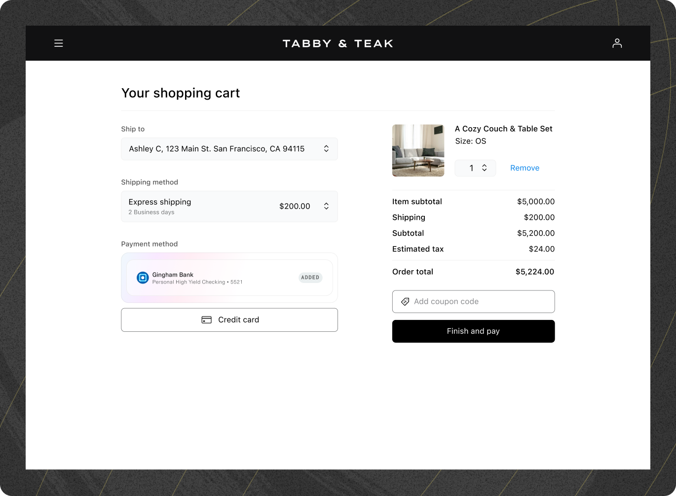 Shopping cart page on the Tabby & Teak website. The shipping address is set to 'Ashley C, 123 Main St, San Francisco, CA 94115,' with the selected shipping method as 'Express shipping' for $200. The payment method shows Gingham Bank (Personal High Yield Checking ending in 5521) as 'Added,' with an option to select 'Credit card' as an alternative. On the right, a summary of the purchase includes 'A Cozy Couch & Table Set' priced at $5,000, shipping at $200, estimated tax of $24, and a total order amount of $5,224. There is an option to enter a coupon code and a button labeled 'Finish and pay.'