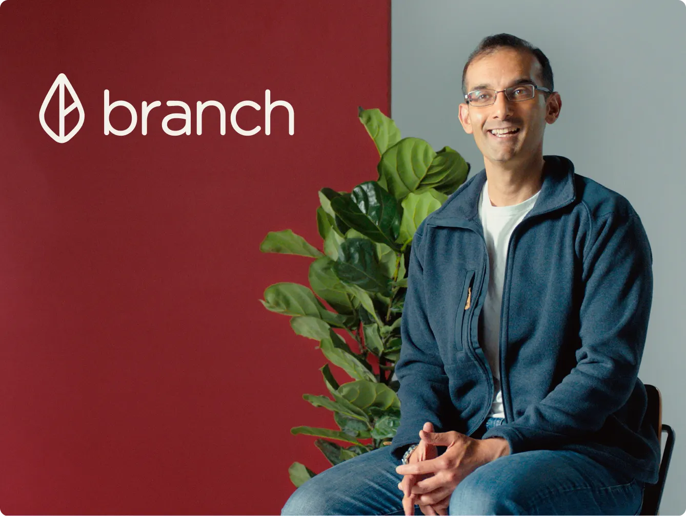 Branch advertisement featuring a smiling man sitting on a chair with a plant in the background. The man is wearing glasses, a blue jacket, and jeans. The Branch logo is prominently displayed at the top left of the image on a maroon and gray background.
