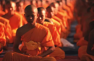 Buddhists dressed in their new saffron robes wait in the meditation hall (Thierry Falise/LightRocket via Getty Images)