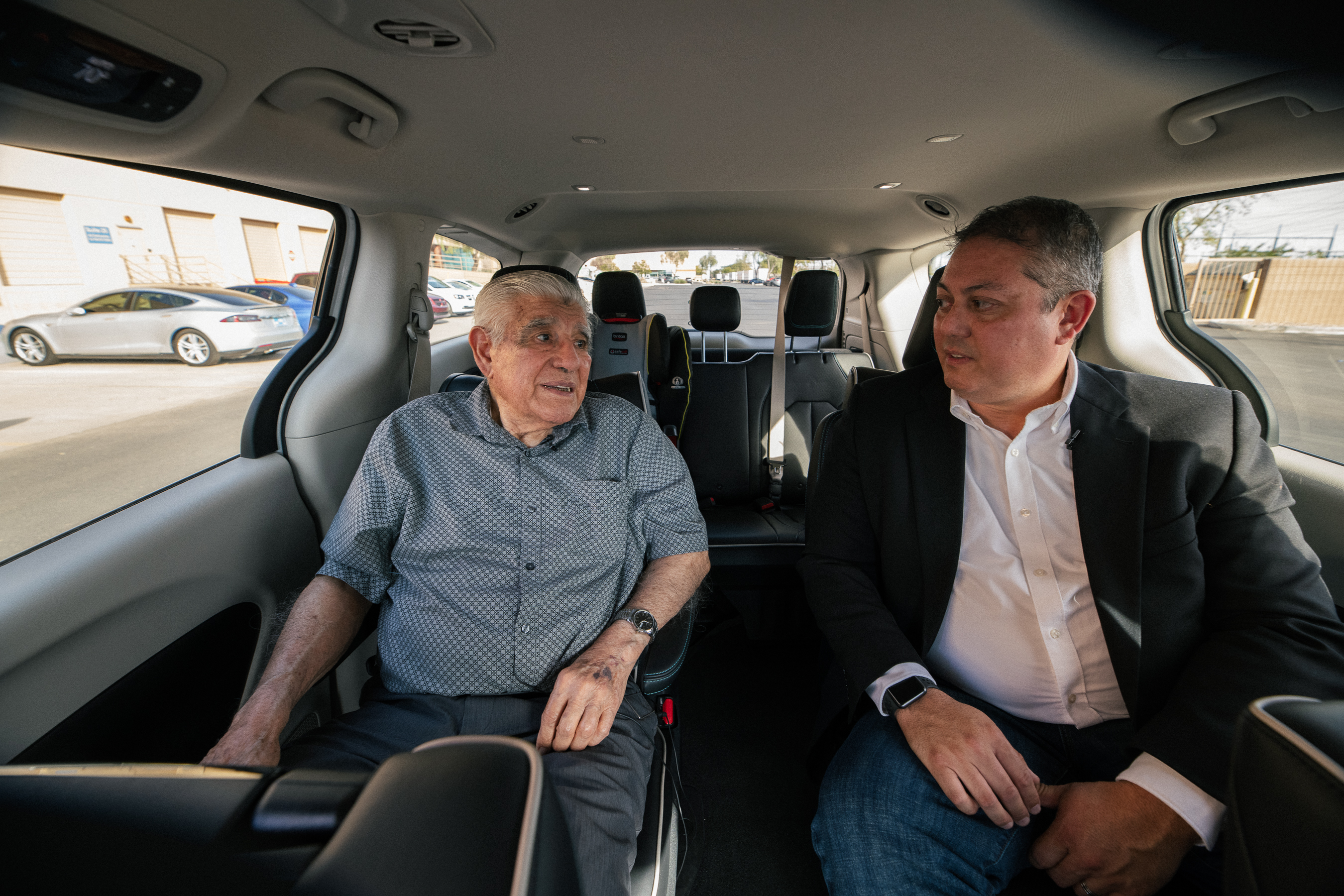 Two men, Santos and Tom Egan, riding in a Waymo vehicle