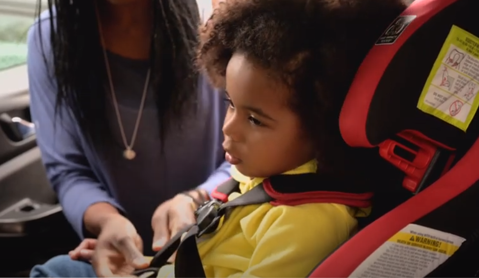 Child getting buckled into a car seat 