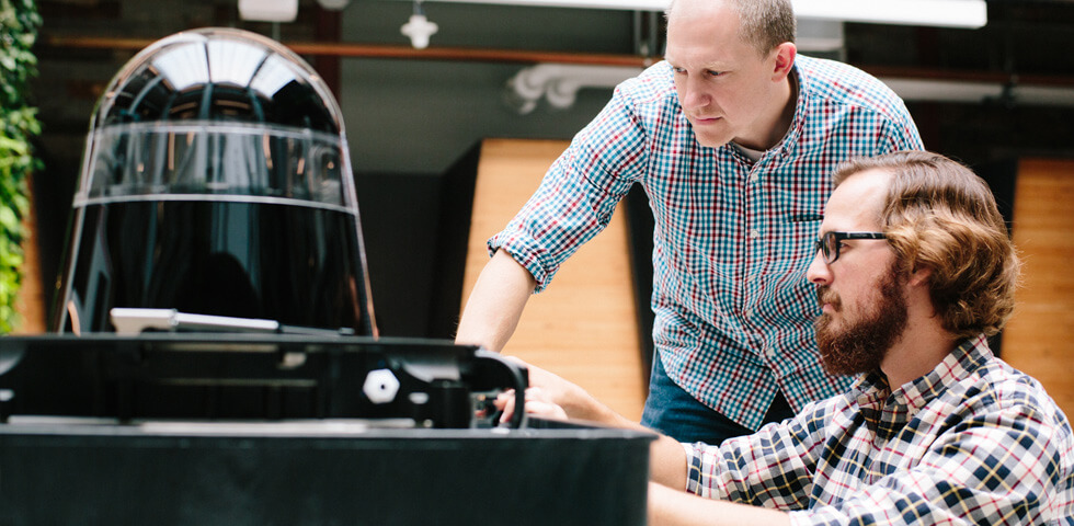 Two men working on a sensor of an autonomous vehicle