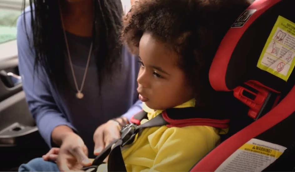 Child being strapped into car seat