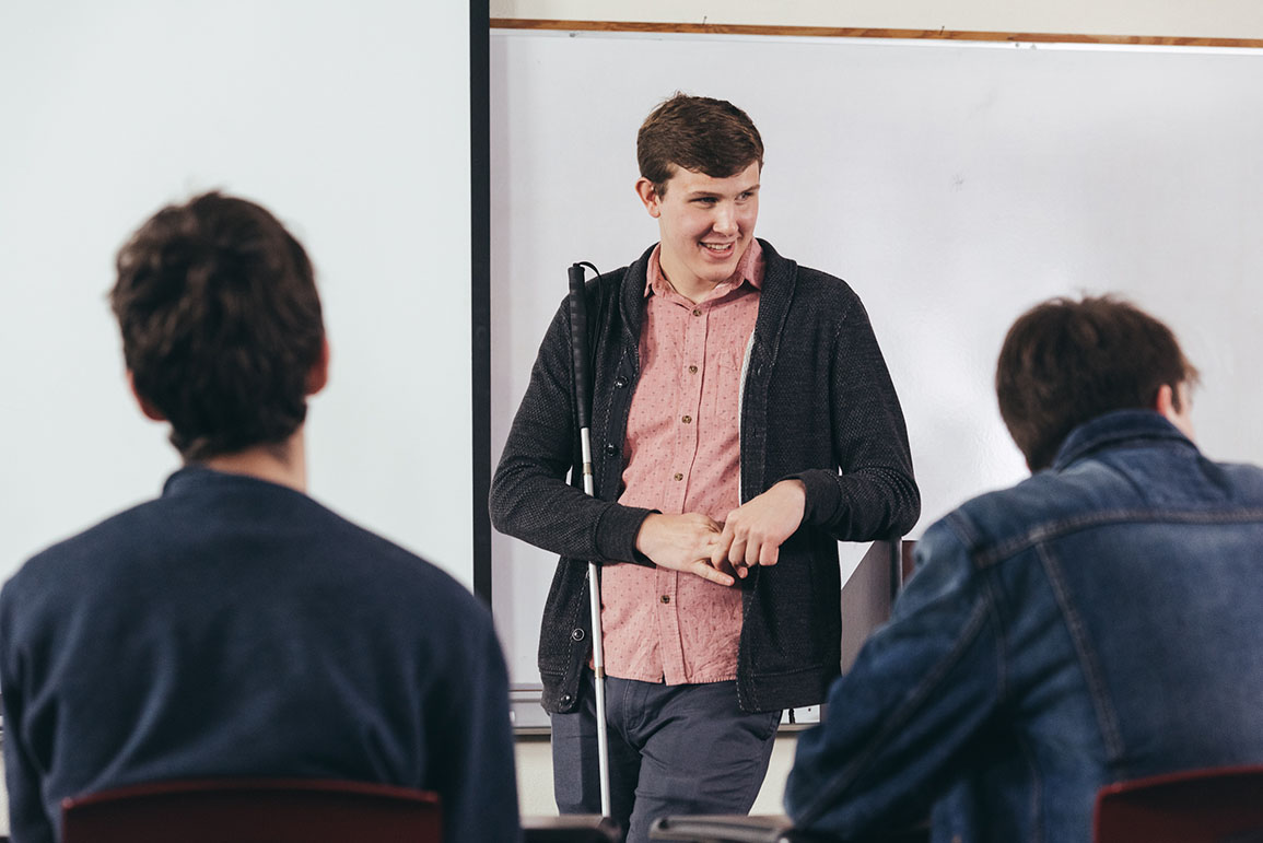 Blind man at the front of a classroom