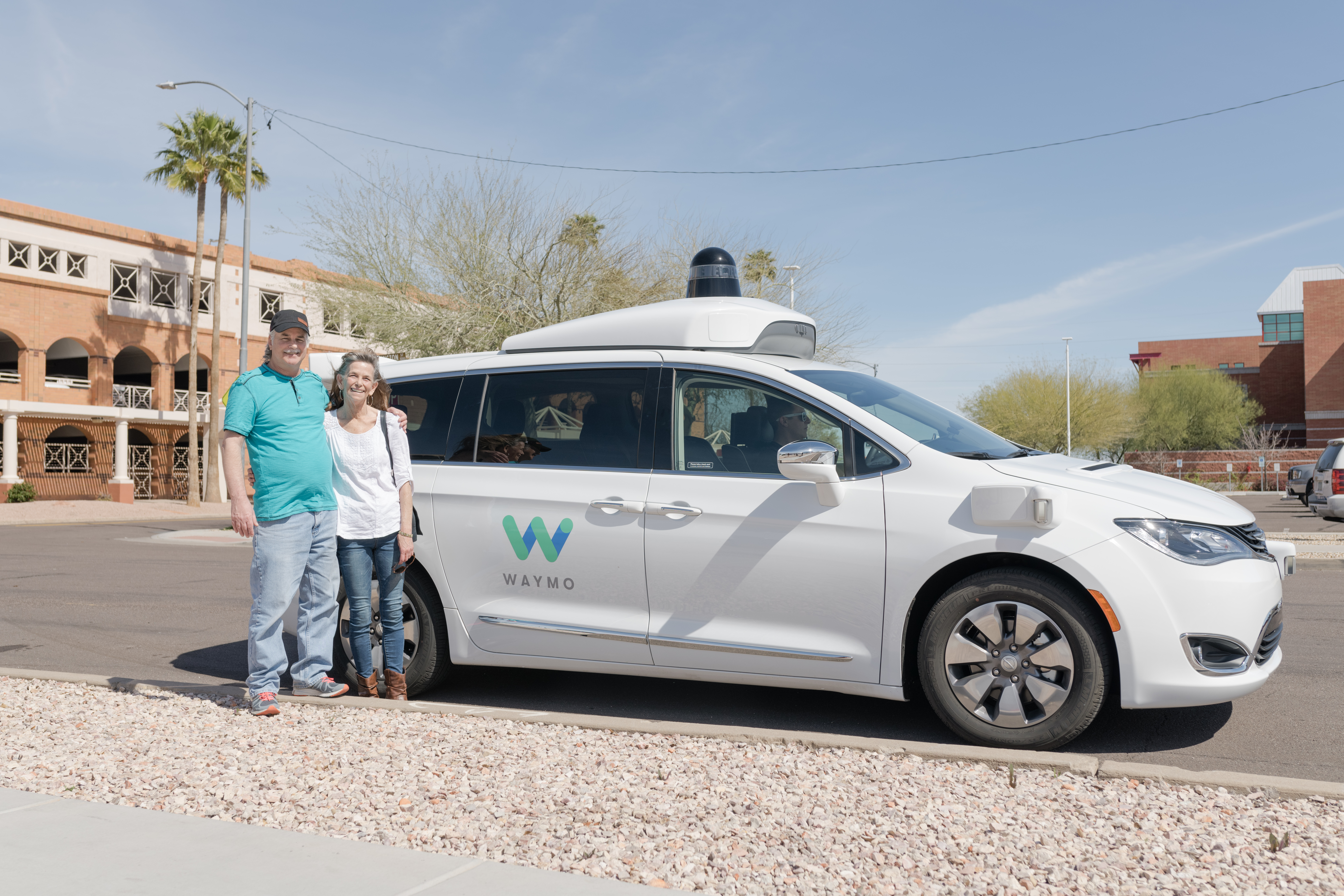 Brian and Sherry in front of a Waymo vehicle