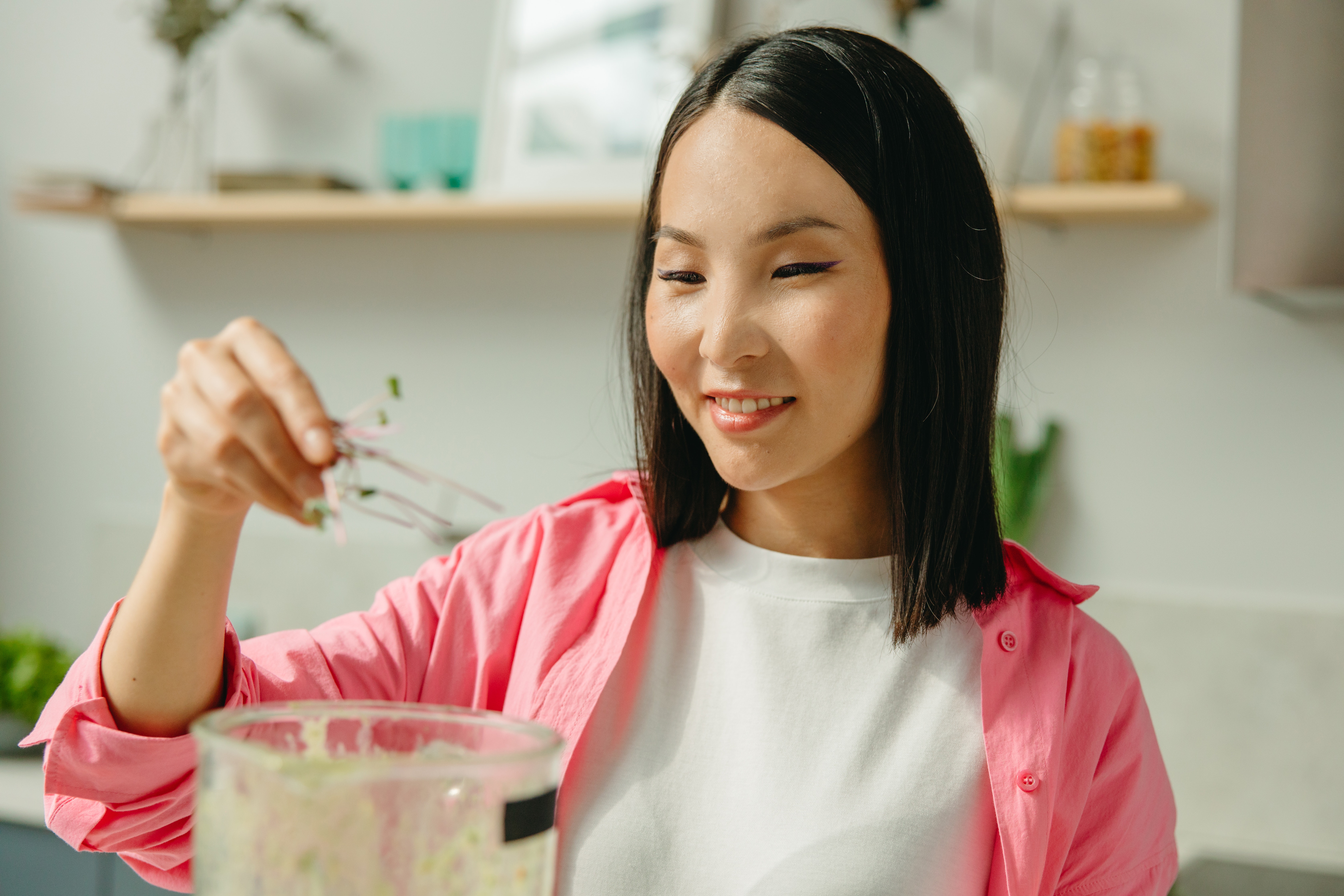 Woman in Pink Long Sleeve Shirt Holding Clear Drinking Glass