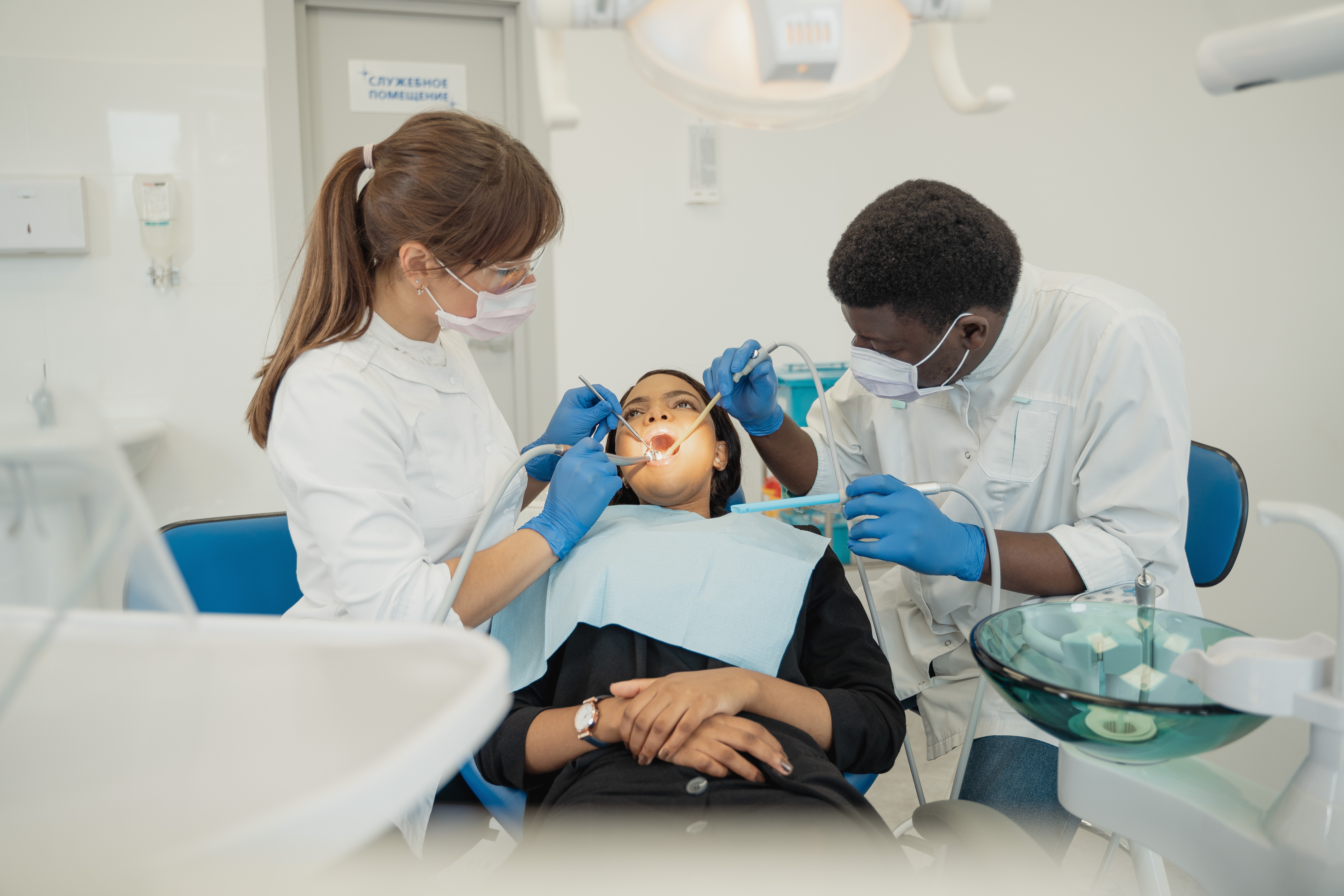 A Dentist Working on a Patient with an Assistant