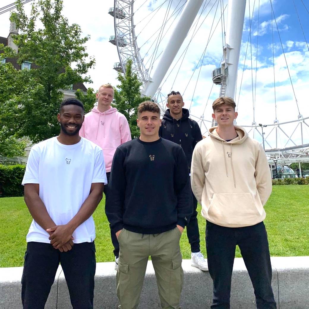 Five men stand outdoors in London wearing Young Goat t shirts and hoodies