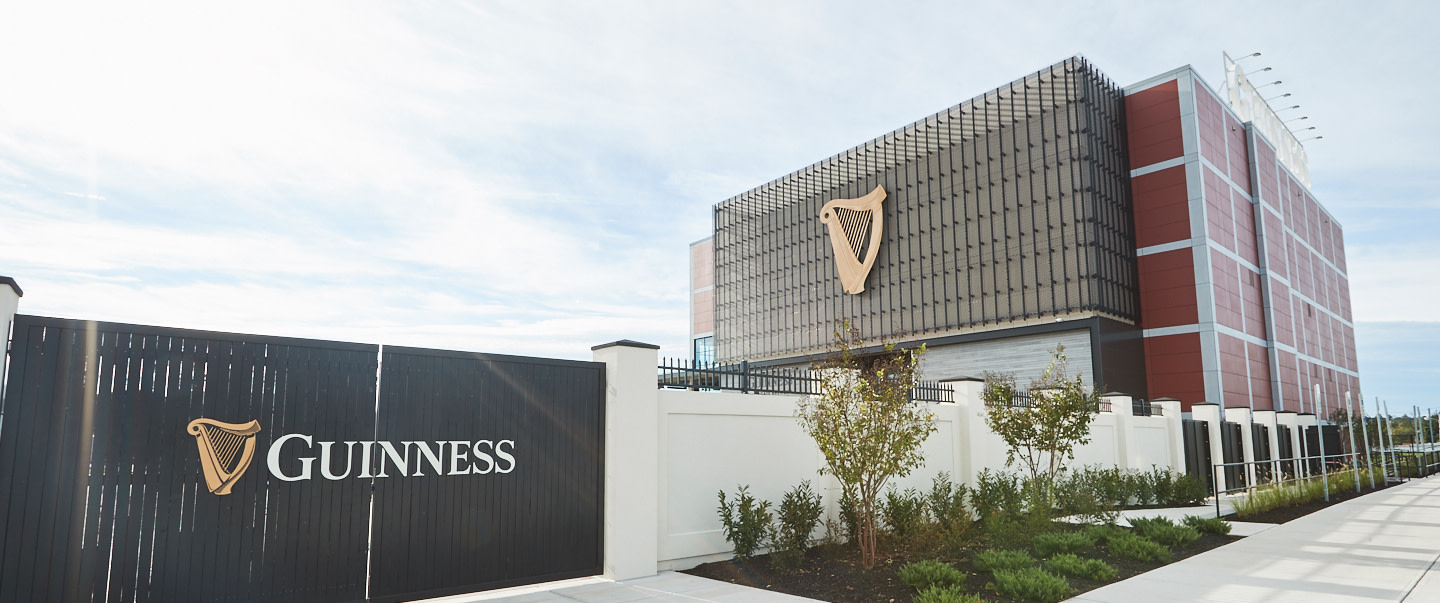Guinness brewery exterior with harp logo on building and branded entrance gate