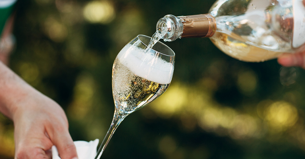 A glass of prosecco being poured.