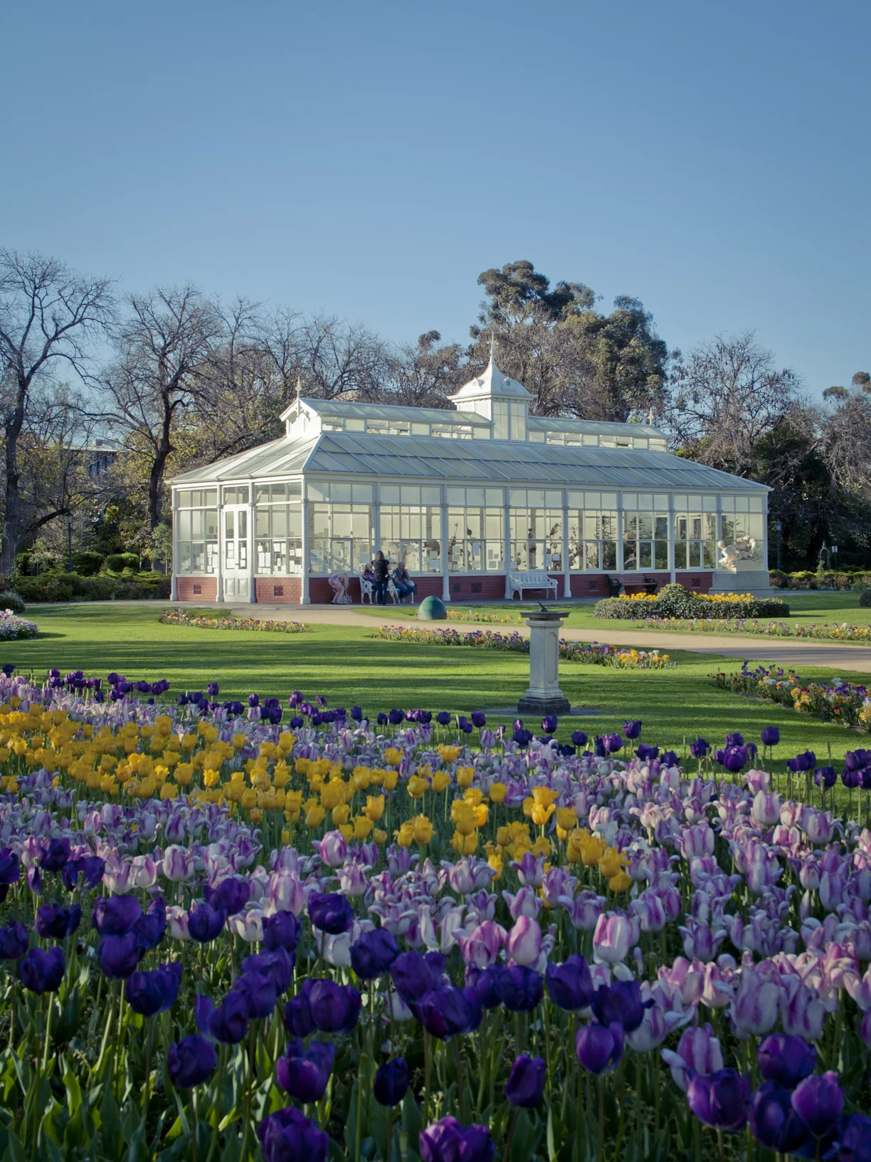 Flowers in the foreground in front of a historical garden conersvatory