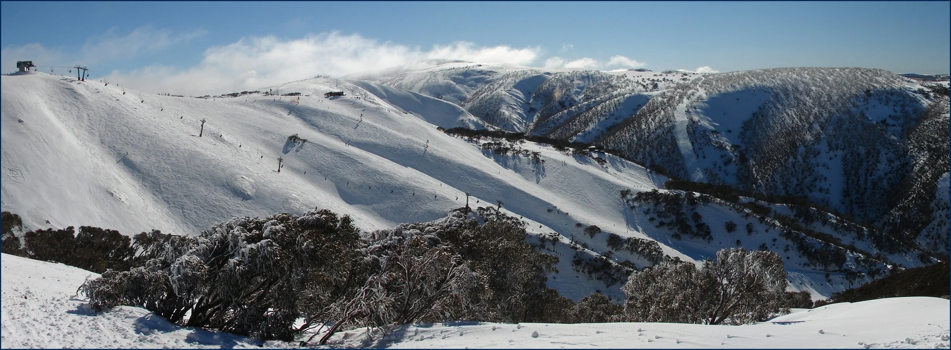 Mount Hotham covered in snow with busy ski slopes.