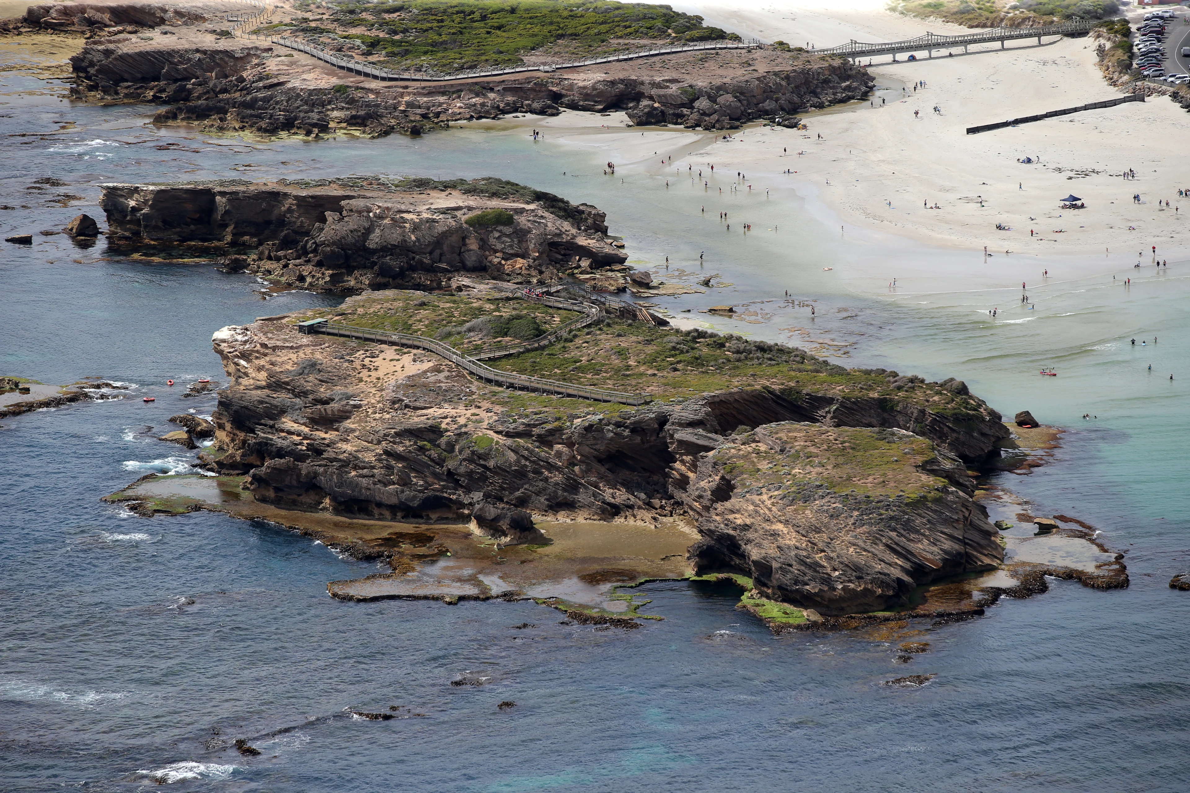 Aerial view of Middle Island and people on the nearby beach. Warrnambool, Victoria.