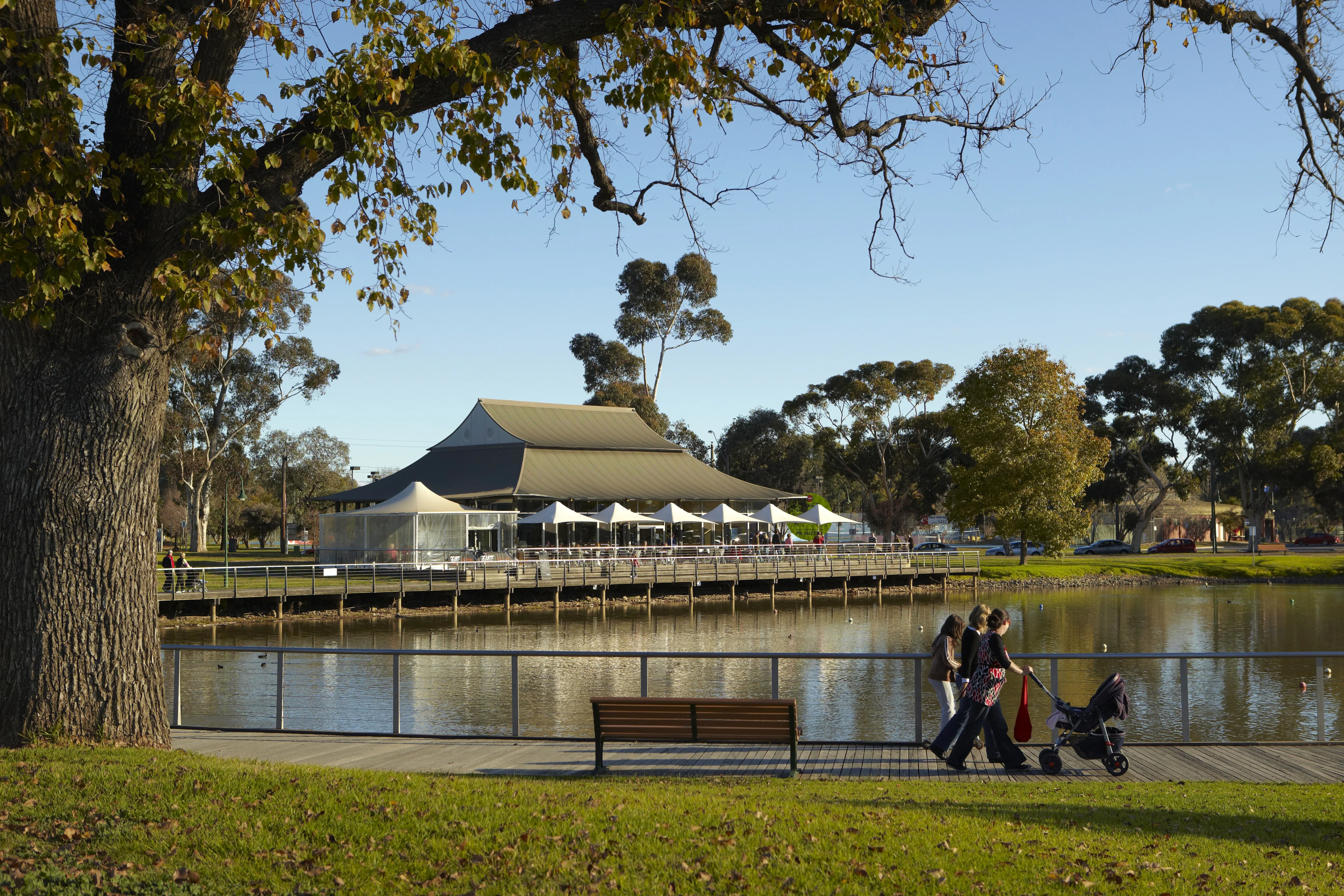 A family with a pram across from The Boardwark Bendigo cafe. Lake Weeroona, Bendigo, Victoria.