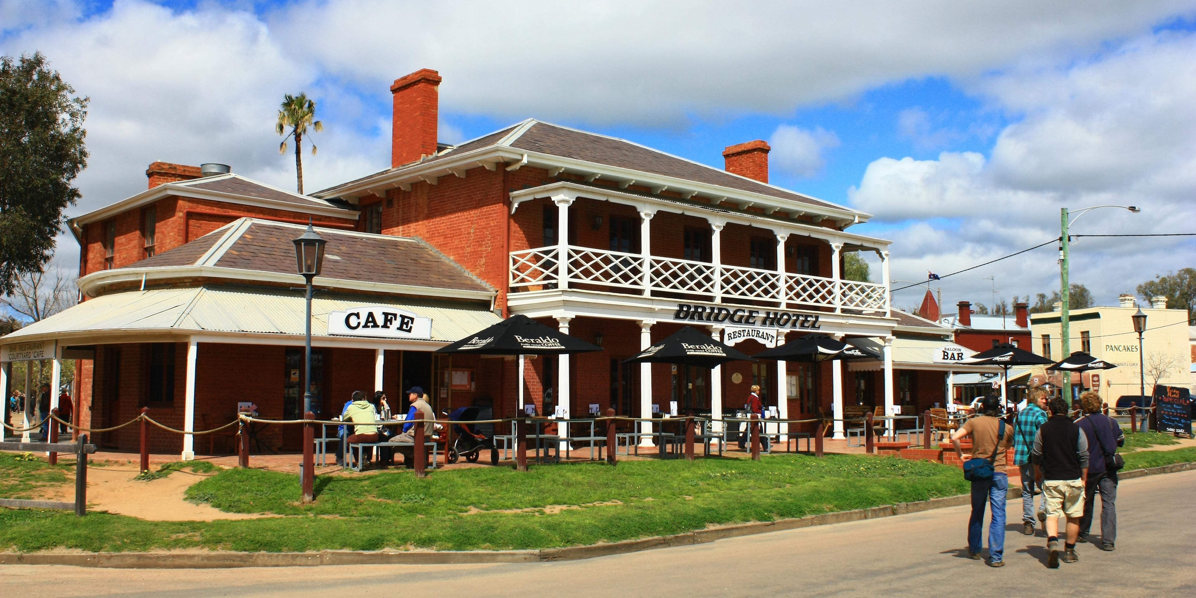 Family in front of cafe, hotel and pub on Main Street, Echuca. 