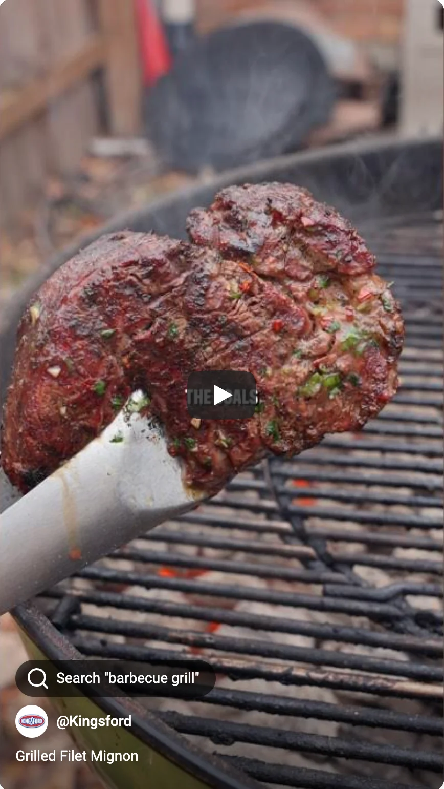 tongs holding a grilled filet mignon over a barbecue grill