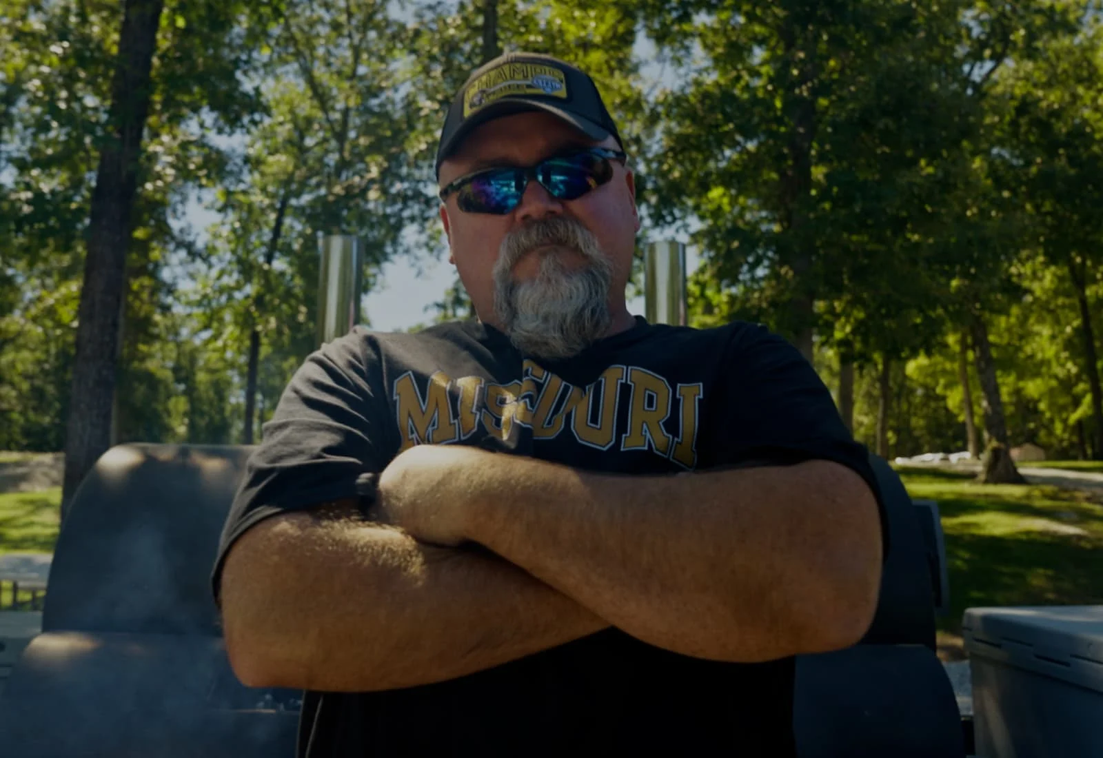 Kirk Newbound standing in front of a grill with his arms folded