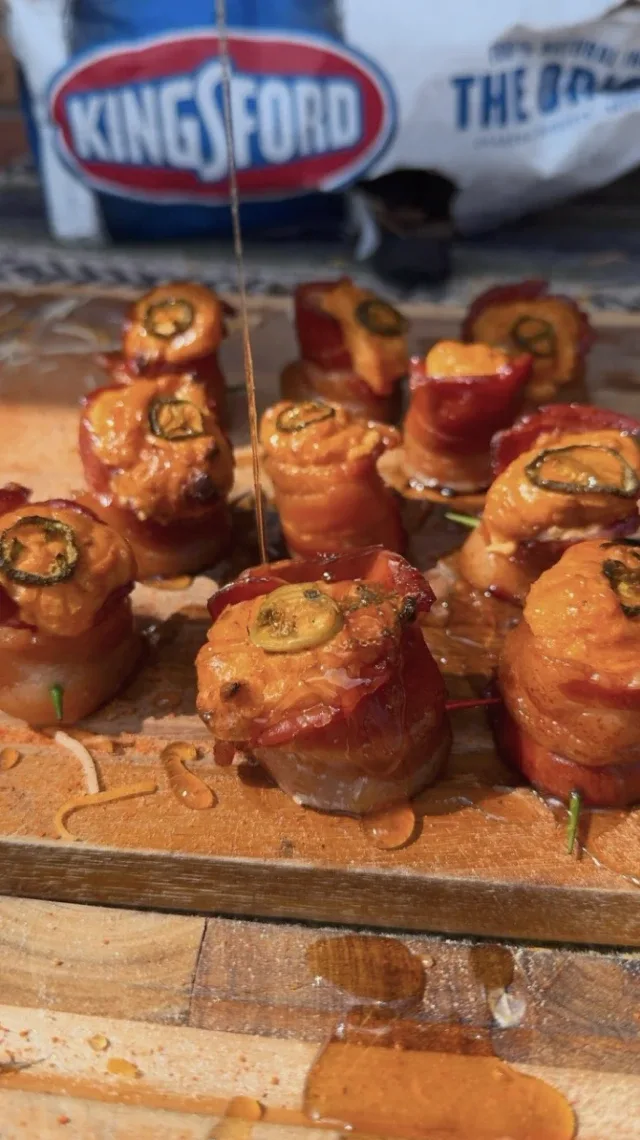 Bacon-wrapped cream cheese bites with a Kingsford charcoal bag in the background