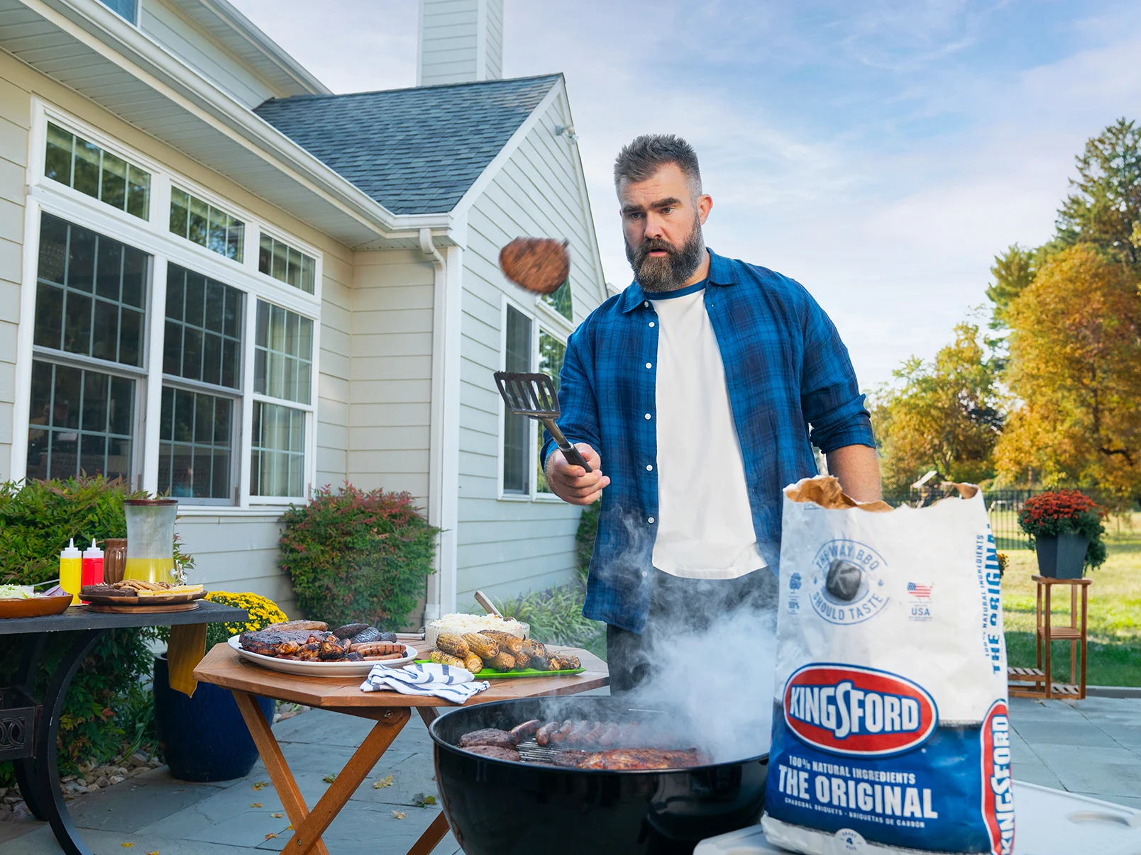 Jason Kelce grilling with Kingsford Charcoal in a backyard