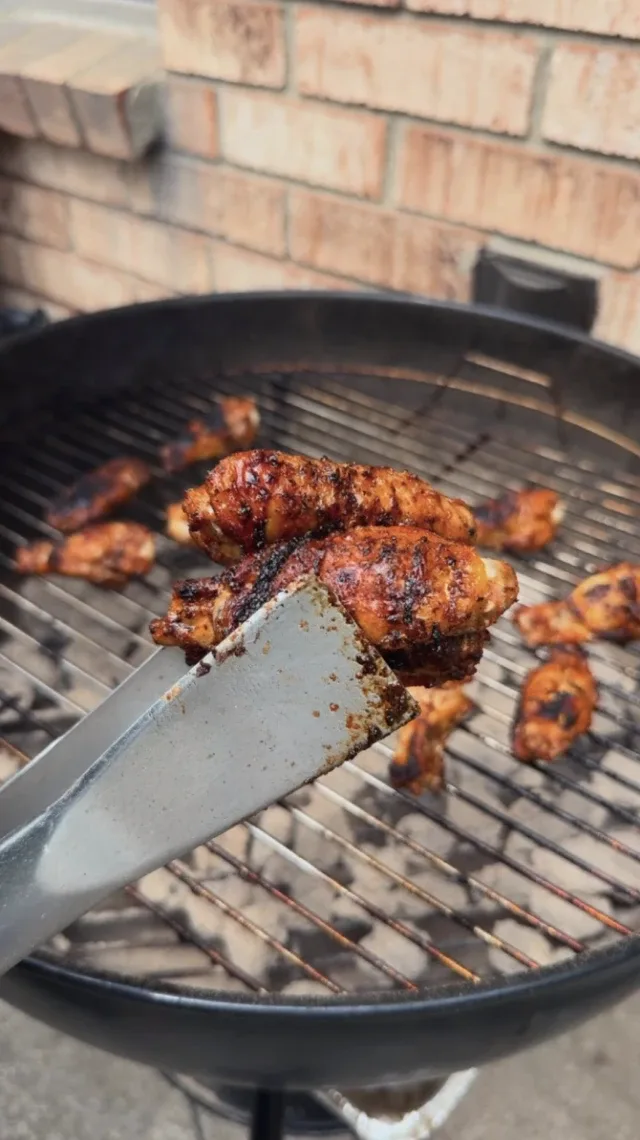 chicken wings grilling on a kettle drum barbecue