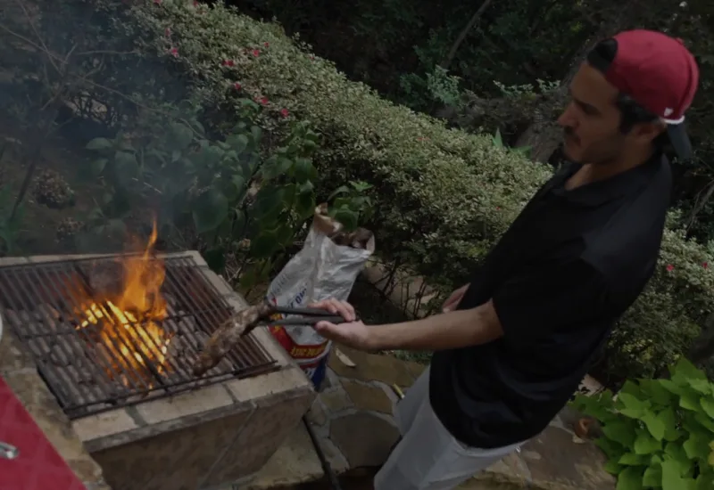 Zain Jiwani barbecuing on a fiery grill