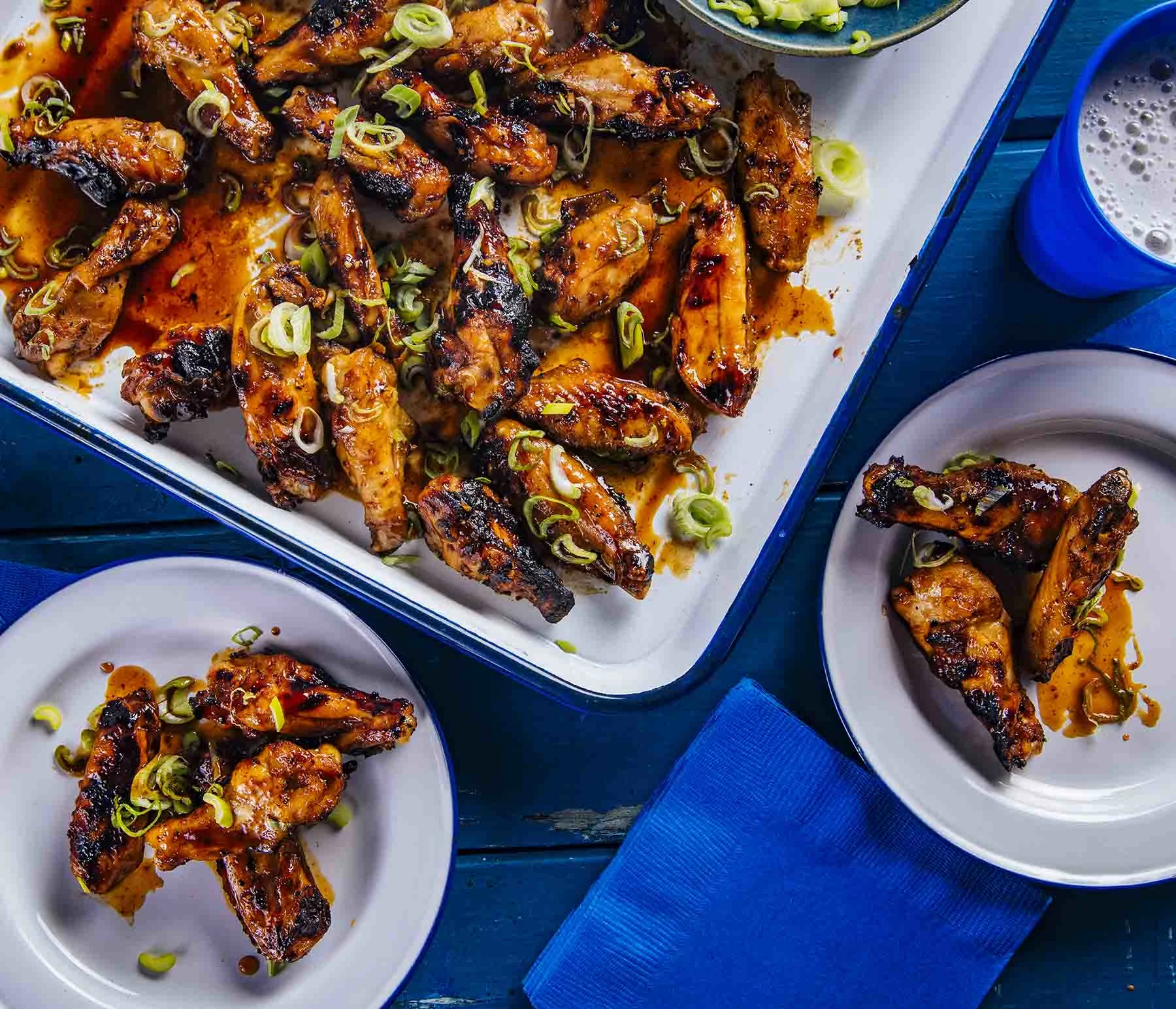 Spicy Korean Chicken Wings in white plates on a blue background