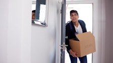 Student moving into new accommodation with a box