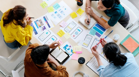 A group of UX designers working on plans for a website.