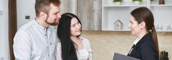 Pasangan suami istri yang tersenyum mendengar penjelasan dari seseorang