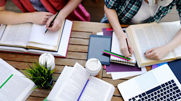 Students revising for exams with a study buddy and looking at notes