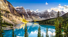 Rocky mountains reflect beneath blue skies into the glacially fed Moraine Lake in Canada's Banff National Park