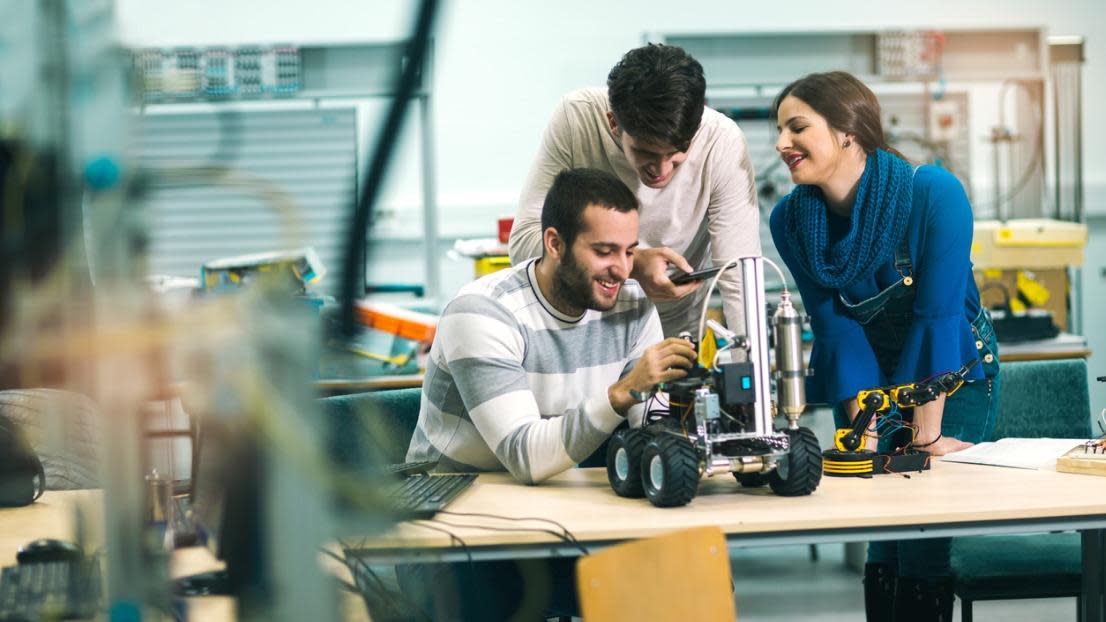 Robotics students preparing a robot for testing