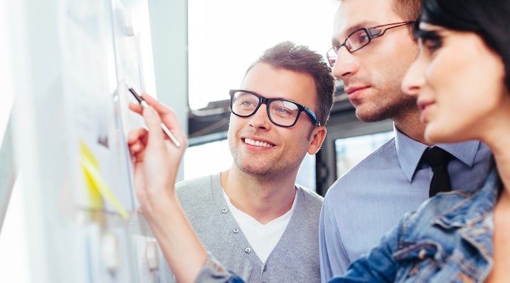 Students discussing business results in front of a board