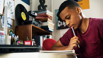 Teenage boy in a bedroom thinking about his personal statement for university