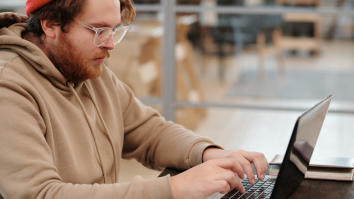 Young man on laptop looking into student loan repayment