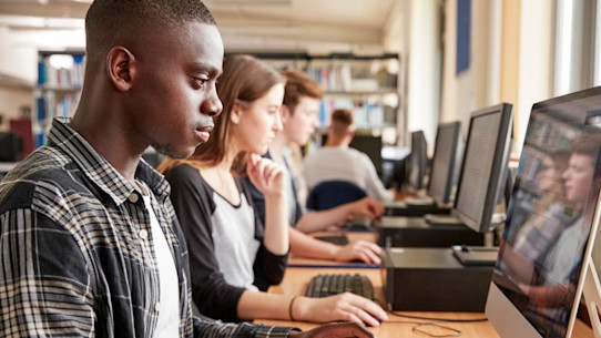 Group Of Students Using Computers In university library