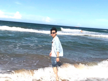 Rokha stands on the beach as a low wave hits his legs