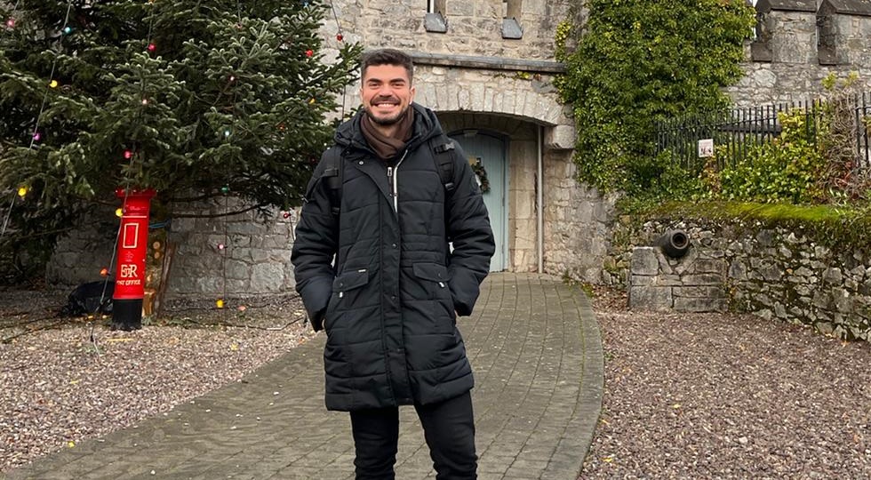 International student Jorge Palomares smiles in front of a Christmas tree outside Blackrock Castle in Cork, Ireland