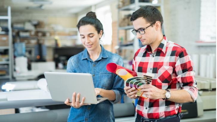 Chatting man and woman watching laptop and discussing work
