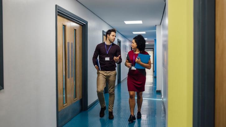 Two teachers conversing in a hallway